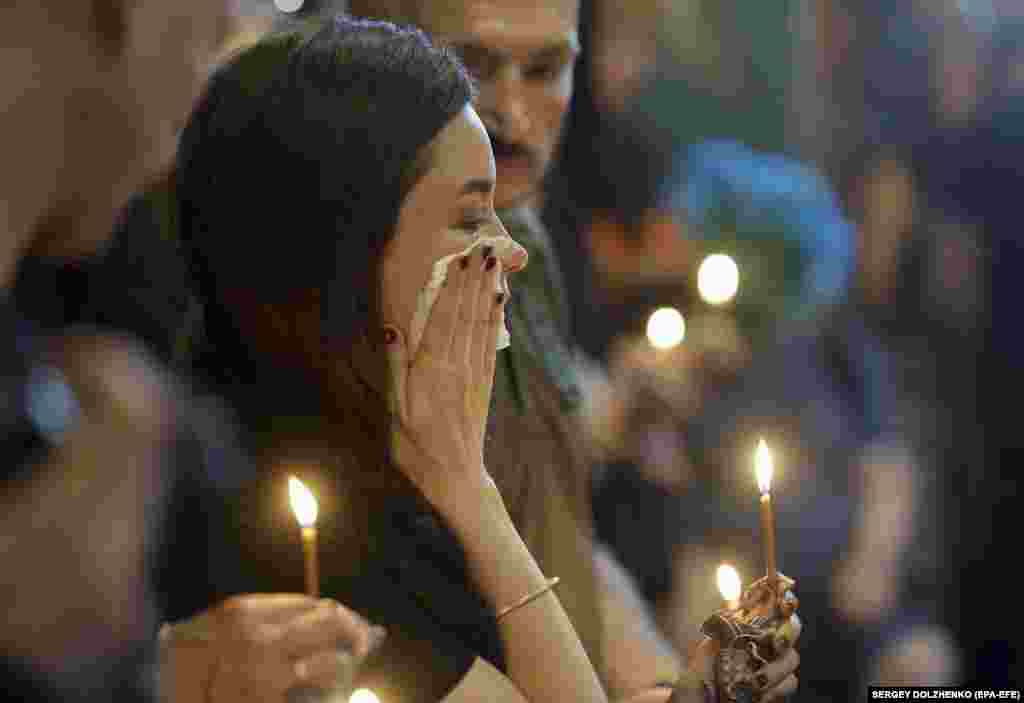 A woman reacts as comrades, relatives, and friends of late Ukrainian military pilot Valentyn Korniychuk attend his funeral ceremony at St. Mikhailovsky Cathedral in Kyiv on June 18.