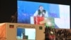 Imran Khan (bottom left) speaks to supporters from behind a bulletproof shield at a rally in Lahore early on March 25. 