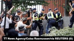 Policajci intervenišu nakon burne reakcije okupljenih ljudi dok je demonstrant palio Kur'an (nije na slici) ispred centralne džamije Štokholmu, 28. juna 2023.