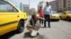 A taxi driver splashes water on his face to cool off in downtown Tehran.