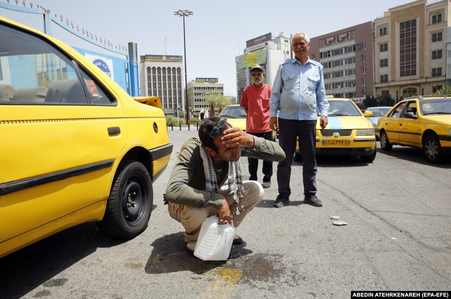 An Tehran taxi driver splashes water on his face in attempt to stay cool during a hot and sunny day in the Iranian capital earlier this month.