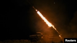 Ukrainian troops fire a BM-21 Grad multiple-launch rocket system toward Russian troops on the front line in the Donetsk region.