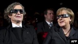  Вендерс и тогавашният канцлер Ангела Меркел с 3D очила преди премиерата на кино лентата 