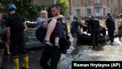 Residents are evacuated from a flooded neighborhood in Kherson, Ukraine, on June 7.