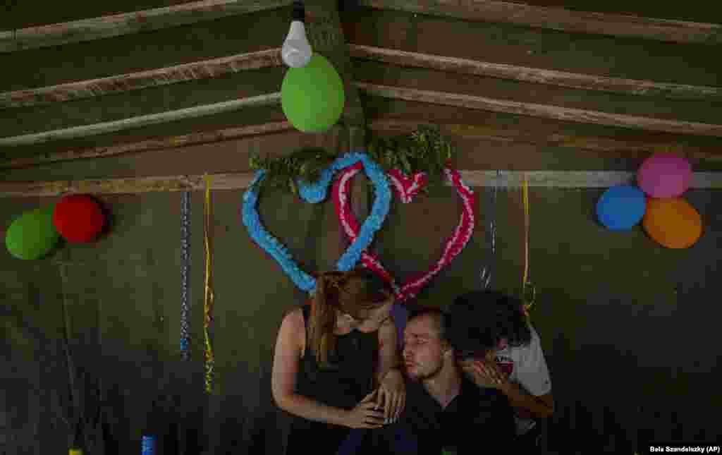 Blind Ukrainian soldier Ivan Soroka (center) surrounded by his wife, Vladislava Ryabets (left) and his mother-in-law during the second day of his wedding on the outskirt of Kyiv.