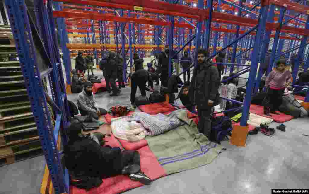 Migranții se pregătesc de culcare într-un centru logistic lângă orașul din Belarus Grodno, aproape de graniță, la 16 noiembrie 2021. Human Rights Watch&nbsp;a acuzat Belarus că a &bdquo;fabricat&rdquo; criza, fără niciun fel de simpatie față de oamenii manipulați.&nbsp; &nbsp;