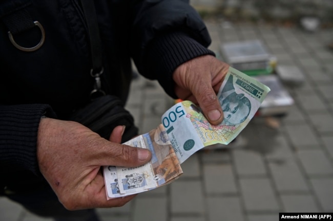Një person në Graçanicë mban në duar dinarë serbë më 1 mars 2024.
