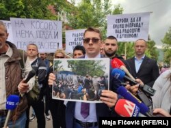 Advokat Obrenovića Predrag Miljković na protestu u Zvečanu pokazao je fotografiju od 29. maja na kojoj se vidi da njegov branjenik sedi na asfaltu, Zvečan 13. juni 2023.