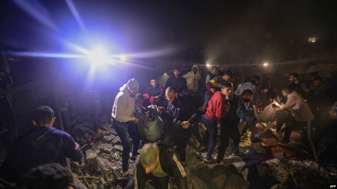 Civili din Rafah caută supraviețuitori în dărâmăturile clădirilor distruse de un bombardament israelian pe 14 decembrie 2023.