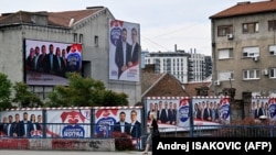 Pešakinja prolazi pored predizbornih bilborda na kojima su predsednik Srbije Aleksandar Vučić i drugi funkcioneri Srpske napredne stranke, Beograd, 31. maja 2024.