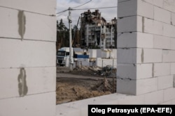 Робітники будують нові будинки на місці зруйнованої під час бойових дій у березні 2022 року будівлі в місті Ірпінь Київської області. 23 жовтня 2023 року