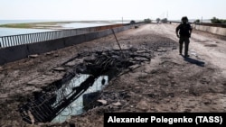 An employee of the Russian Investigative Committee visits the Chongar Bridge, which connects Russian-occupied Crimea with mainland Ukraine and was damaged by a Ukrainian strike on June 22.