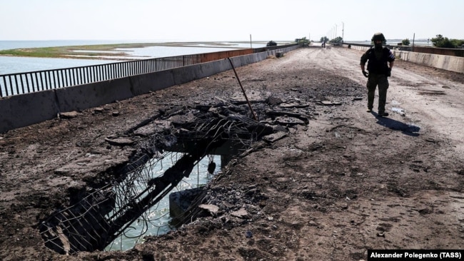 Un dipendente del comitato investigativo russo visita il ponte Chongar, che collega la Crimea occupata dai russi con l'Ucraina continentale e che è stato danneggiato da uno sciopero ucraino il 22 giugno.
