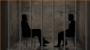 Two silhouettes in a prison cell