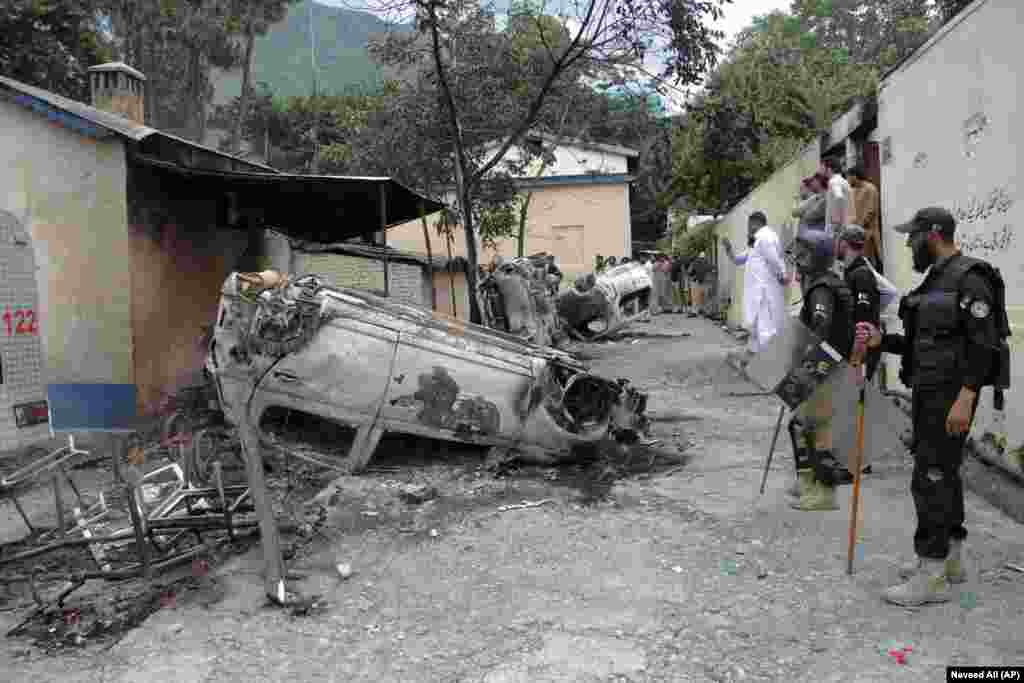 Police officers examine burned vehicles that were torched by a Muslim mob in an attack in Madyan in Pakistan&#39;s Khyber Pakhtunkhwa Province. A Muslim mob broke into a police station, abducted a man who was held there, and then lynched him over allegations that he had desecrated Islam&#39;s holy book, the Koran.