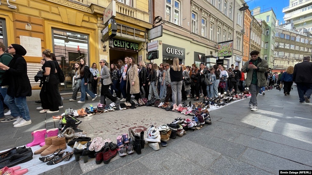 Njerëz duke ecur në përvjetorin e fillimit të rrethimit të Sarajevës, pranë këpucëve që simbolizonin qytetarët e vrarë, më 5 prill.