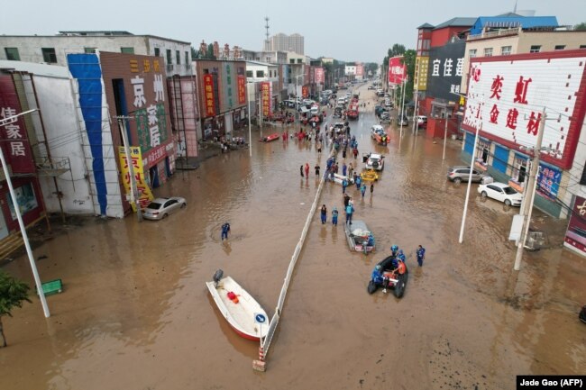 Ekipet e shpëtimit që punojnë në një fshat të përmbytur pas shirave të dendur në Zhuozhou, Kinë, 2 gusht 2023.
