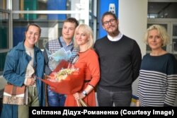 Біженка Світлана і її син (по центру) на фотовиставці. Жінка отримала грант Ради культури Литви та влаштувала виставку «Фантомні сім’ї реальної війни»