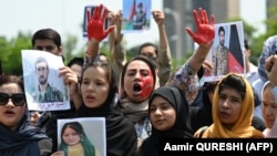 Afghan nationals carry placards as they shout slogans during a demonstration against the Taliban-led government in Islamabad on August 15.