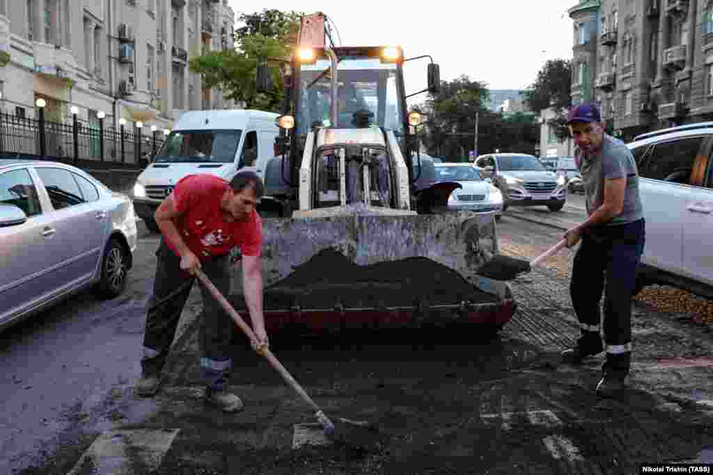 Workers repair a road in Rostov-on-Don on June 25. Road surfaces in the southern Russian city were damaged by tank tracks after&nbsp; mercenary leader Yevgeny Prigozhin led an armed rebellion on June 24 that seized the Southern Military District headquarters in Rostov-on-Don.