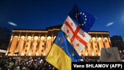 Протестиращите издигнаха европейски и украински знамена, наред с грузинските.