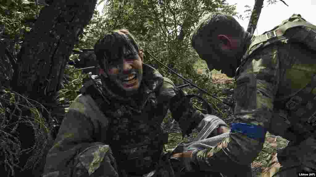 Un soldat ucrainean acordă primul ajutor unui camarad rănit, în vârstă de 19 ani, pe 4 septembrie. Unitatea se luptă cu forțele rusești în apropierea orașului Bahmut din estul țării. Situația pe linia de front din est rămâne dificilă pentru trupele ucrainene în timp ce acestea se apără și previn pierderea pozițiilor, a declarat generalul Oleksandr Sîrski, comandantul forțelor terestre ucrainene, pe 6 septembrie.