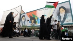 Иранка носи палестинско знаме за време на митинг за поддршка на Палестинците во Техеран, 13 октомври 2023 