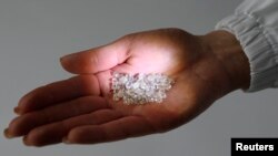 Nyers gyémántok az Alrosa orosz gyémántbányászati cég egyik alkalmazottjának tenyerében