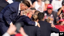  Кръв се стича по дясното ухо на Тръмп, до момента в който сътрудниците на Сикрет сървис го извеждат от сцената. 