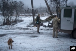 Українські військові переносять пораненого солдата на стабілізаційному пункті поблизу Бахмуту, 26 січня 2024 року