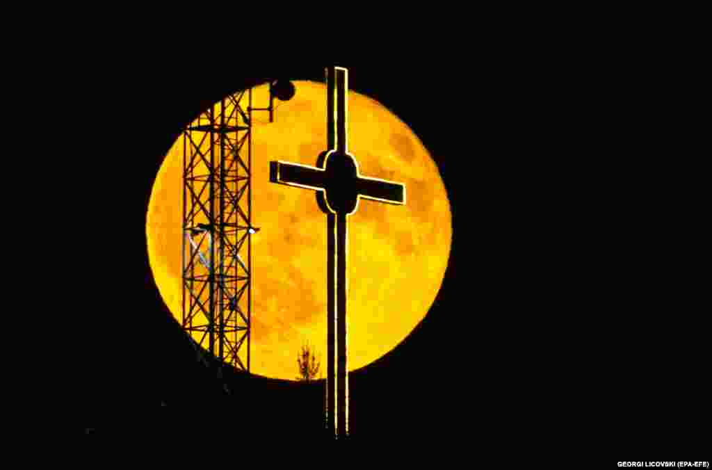 A full moon, also called a Buck Moon, rises behind a giant cross on a hill near Dracevo, Skopje, North Macedonia.&nbsp;