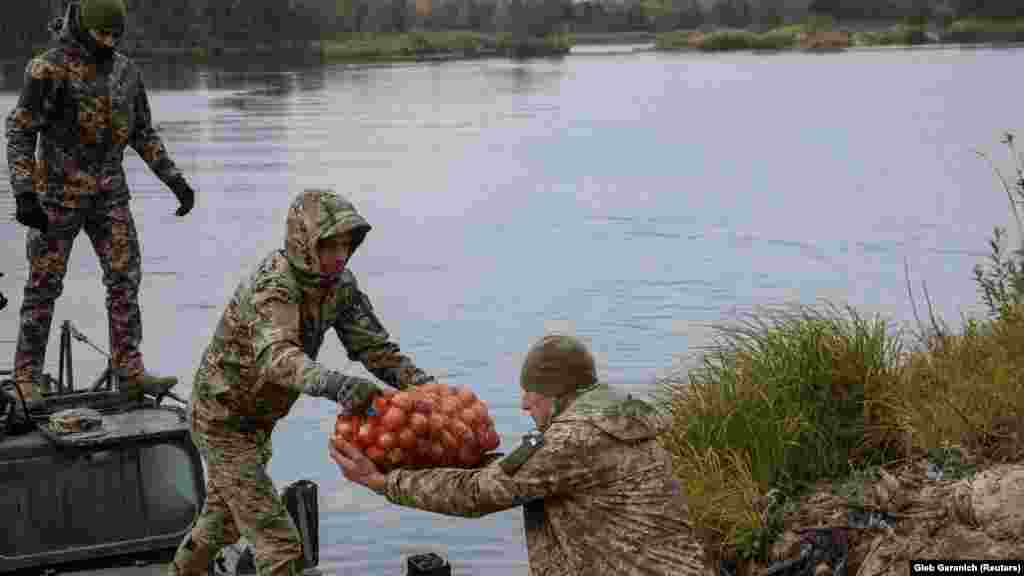 Ushtarët ukrainas duke bartur ushqime nga një varkë, të cilat do t&#39;u dërgohen banorëve të moshuar. &nbsp;