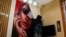 O cosmeticiană din Kabul, Afganistan, înlătură un poster dintr-un salon de înfrumusețare, pe 24 iulie 2023.