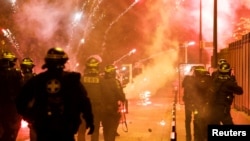 Rendőrök tűzijáték-rakéták kereszttüzében Nanterre-ben, Párizs külvárosában 2023. június 30-án