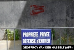 Fotografie făcută în arondismentul 7 al Parisului pe 8 iunie 2024, în care apare un graffiti cu un sicriu și inscripția „Soldați francezi în Ucraina”, în spatele unui gard pe care scrie „proprietate privată, accesul interzis”