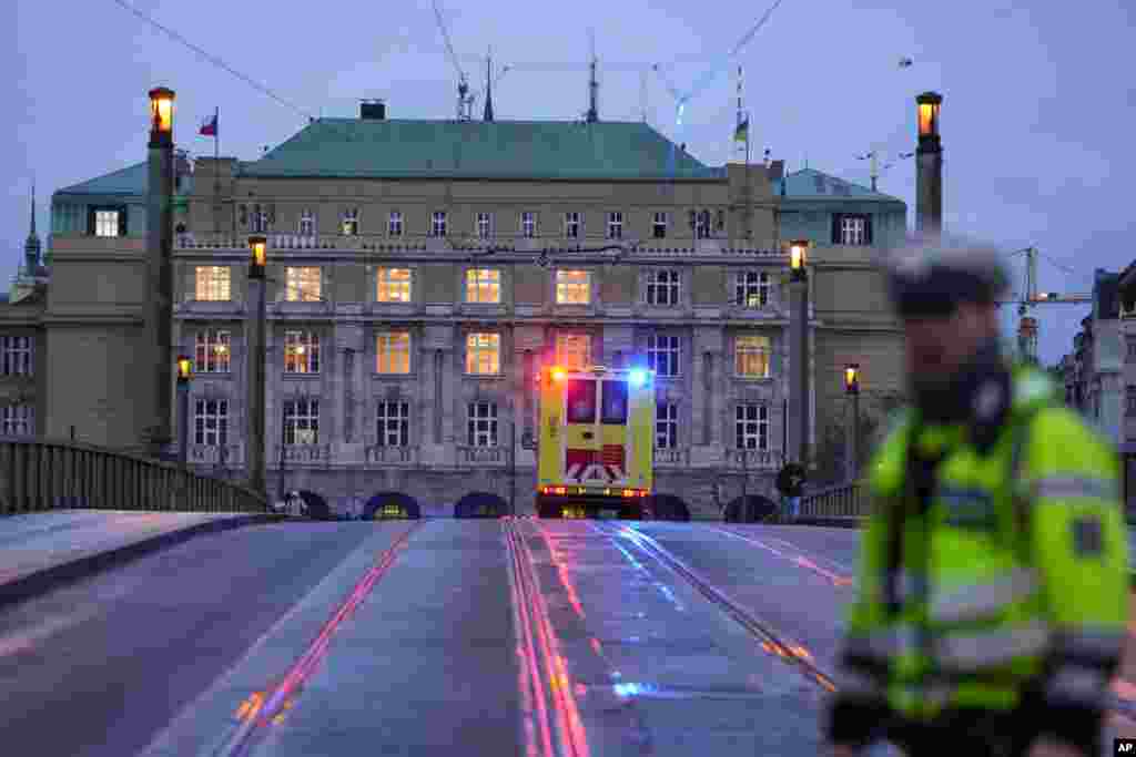 Policajac i hitna pomoć ispred&nbsp;Filozofskog fakulteta Karlovog univerziteta nakon policijske akcije, 21. decembra 2023. Umjesto na predavanje, David K. je otišao u glavnu zgradu fakulteta, isto u turističkom srcu Praga, unio u torbi više komada vatrenog oružja i municiju i zatim otvorio vatru, na putu do krova gdje je kasnije pucao u sebe. Otvorio je vatru i na prolaznike na trgu ispred fakulteta.