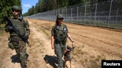 Lithuanian security officers patrol along their country's border with Belarus on July 7. 