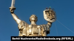 На щиті монумента «Батьківщина-мати», який мають перейменувати на «Україна-мати», вже встановили тризуб замість радянського герба. Київ, 6 серпня 2023 року