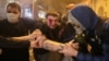 Protesters help an injured man during a rally in Tbilisi after police fired tear gas and water cannons.