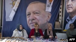 Жени раздават предизборни брошури на фона на плакат с лицето на Реджеп Тайип Ердоган. Снимката е от 22 май в Истанбул