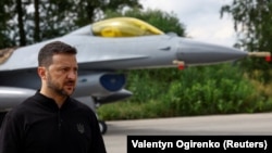 President Volodymyr Zelenskiy speaks to the media in a front of an F-16 fighter in an undisclosed location in Ukraine on August 4. 