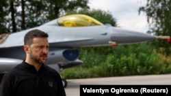 Ukrajinski predsjednik Volodimir Zelenski, govori za medite ispred F-16 mlaznjaka, nepoznata lokacija, 4. avgust 2024.
