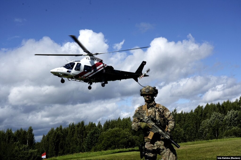 Një helikopter i Gardës Kufitare Shtetërore Letoneze niset nga Lidumnieki për të inspektuar zonën pranë kufirit mes Bjellorusisë dhe Letonisë më 8 gusht. Letonia, Polonia dhe vende të tjera në krahun lindor të NATO-s kanë shprehur shqetësime për një kërcënim të mundshëm nga Bjellorusia, e cila tani strehon mijëra trupa që i përkasin grupit mercenar Wagner.