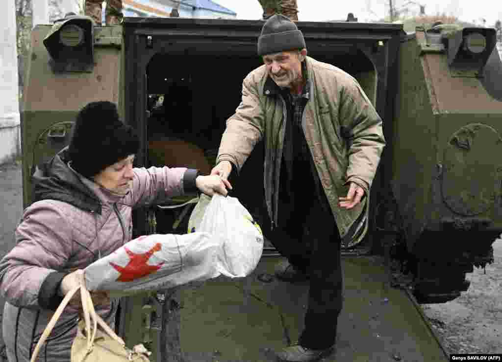 Civilët e shpëtuar nga Bahmuti mbajnë gjërat e tyre personale ndërsa dalin nga një transportues i blinduar ukrainas në Çasiv Jar. Ata do të dërgohen më larg nga zona e luftës në një strehë për personat e zhvendosur brenda vendit në Kostjantjnivka.