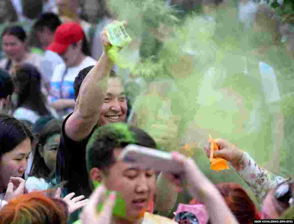 Participants throw colored dye into the air and at each other, creating a lively and colorful atmosphere.&nbsp;