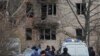 Rescue workers and investigators gather near a damaged residential building in St. Petersburg following an alleged drone attack on March 2