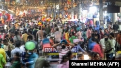 Njerëzit duke ecur nëpër një treg në Xhalandahar, Indi, më 23 tetor 2022.