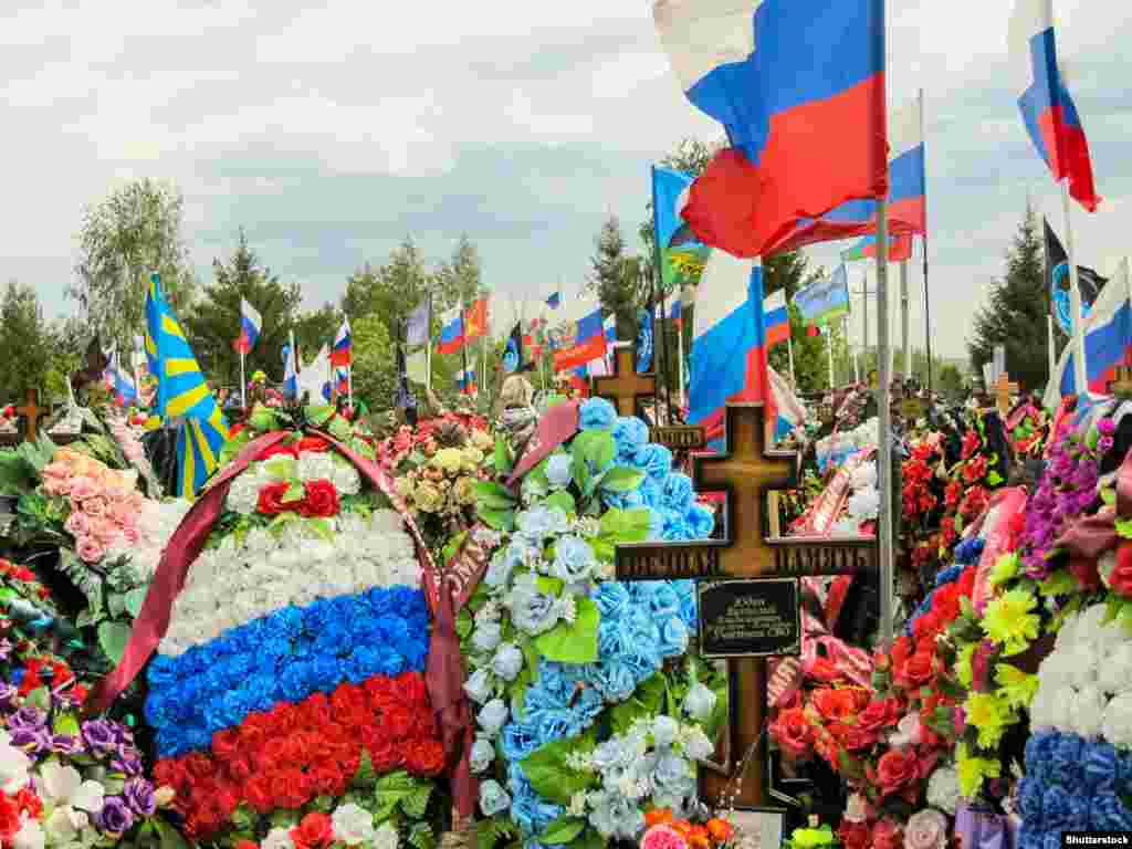 Fotografitë nga varrezat ushtarake ruse janë të rralla, me gazetarët që rrezikojnë të dënohen ashpër për përhapjen e &quot;lajmeve të rrejshme&quot; për ushtrinë ruse. Kjo fotografi nga maji 2024, e një varreze në rajonin Tambov në Rusi, shfaq banere ushtarake dhe një pllakë përkujtimore për një pjesëmarrës të asaj që Kremlini e cilëson si &quot;operacion special ushtarak&quot; në Ukrainë.