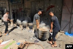 Ljudi kuhaju na drva za ogrjev, zbog nestašice goriva i plina, kako bi osigurali hranu za raseljene Palestince usred izraelskih udara u Khan Yunisu, u južnom pojasu Gaze, 15. oktobra 2023.