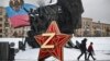 Хора преминават покрай кремълска петолъчка с буквата Z, емблема на руските агресори в Украйна, на фона на паметник на героите в Първата световна война. Москва, 26 декември 2023 г.